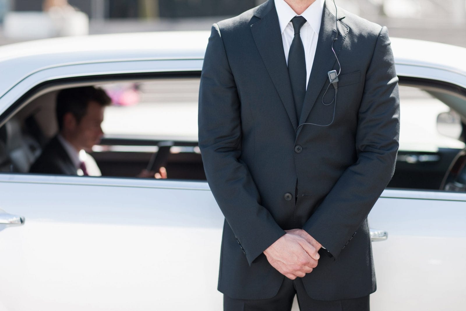 Bodyguard protecting politician in backseat of car